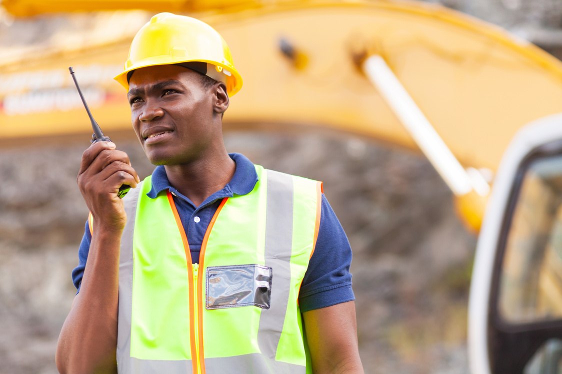 Mine worker in high-visibility gear speaking on a radio